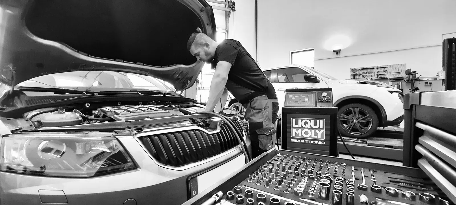 KFZ-Mechaniker repariert Fahrzeug in der Werkstatt Achis Garage Kirchlengern